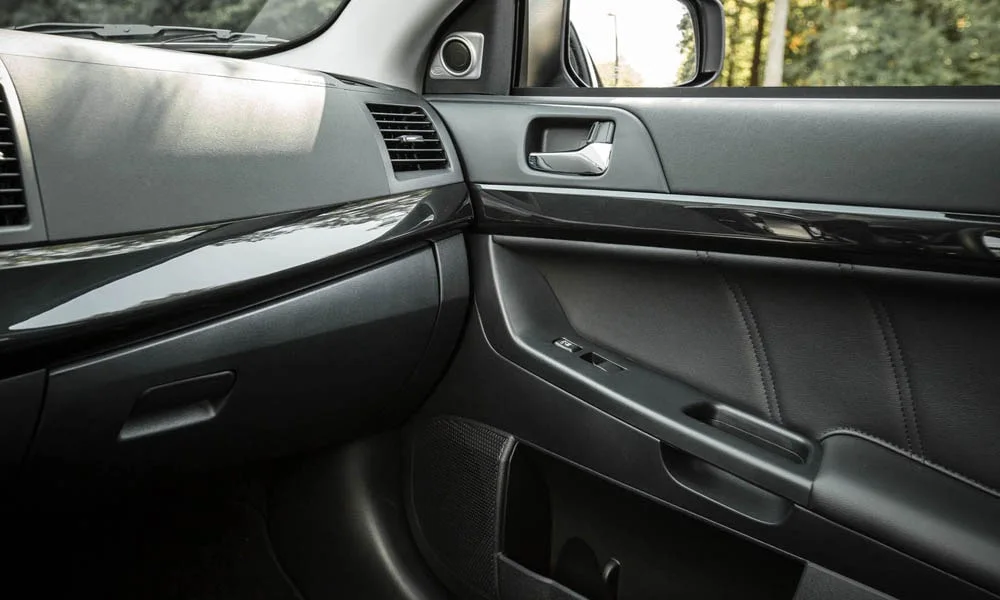 Фото Mitsubishi Lancer — интерьер. Общий план салона: архитектура панели, консоль и кресла. Уровень отделки читается по стыкам панелей и мягким поверхностям в зонах касания Mitsubishi Lancer — интерьер
