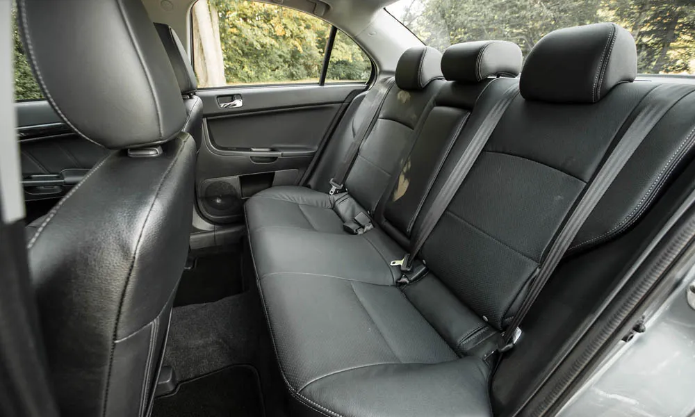 Фото Mitsubishi Lancer — задние сиденья, фото 2. Посадка второго ряда: подголовники и подлокотник Mitsubishi Lancer — задние сиденья, фото 2