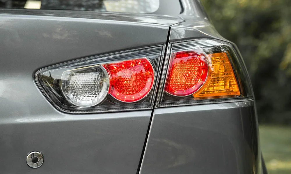 Фото Mitsubishi Lancer — задние фонари. Графика секций крупным планом — ночная подпись модели. Динамические поворотники с бегущей индикацией встречаются в старших комплектациях Mitsubishi Lancer — задние фонари
