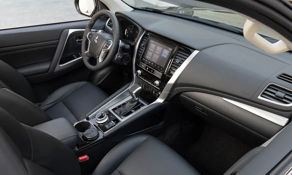 Фото Mitsubishi Pajero Sport — передняя панель. Компоновка экранов, дефлекторов и консоли. Минимум физических кнопок — ставка на экранное управление Mitsubishi Pajero Sport — передняя панель