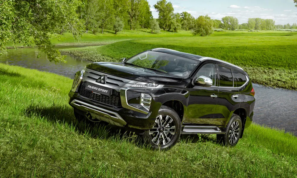 Фото Mitsubishi Pajero Sport — вид спереди, фото 3. Кузов в чёрном цвете: рисунок оптики и решётки задаёт узнаваемое «лицо» модели Mitsubishi Pajero Sport — вид спереди, фото 3