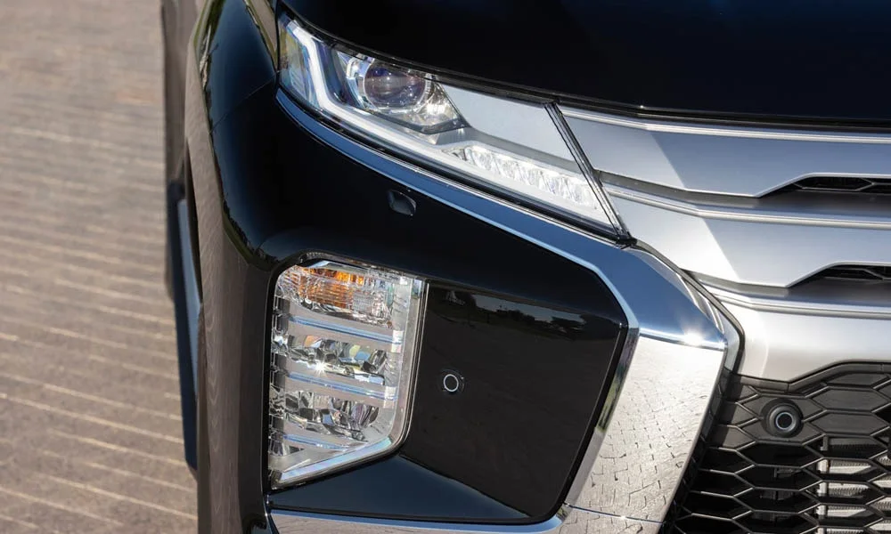 Фото Mitsubishi Pajero Sport — вид спереди, фото 5. Анфас: пропорции капота, посадка кузова и графика ходовых огней. Дневные ходовые огни включаются автоматически с запуском Mitsubishi Pajero Sport — вид спереди, фото 5