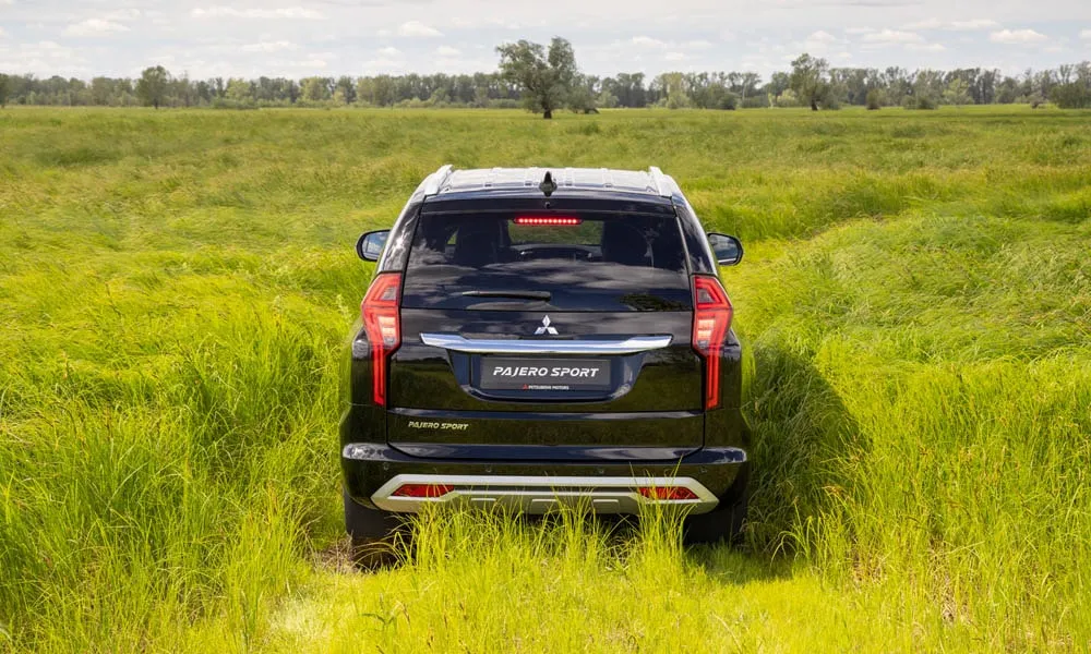Фото Mitsubishi Pajero Sport — вид сзади, фото 8. Корма в чёрном цвете: графика фонарей и пластика пятой двери. Насадки выхлопа или их имитация внизу бампера различают версии Mitsubishi Pajero Sport — вид сзади, фото 8