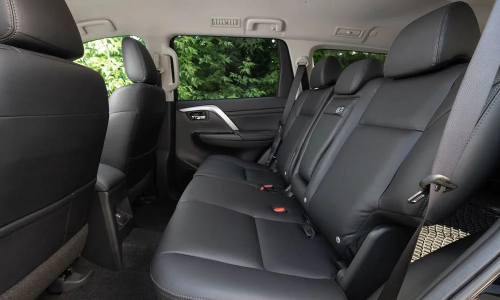 Фото Mitsubishi Pajero Sport — задние сиденья. Посадка второго ряда: подголовники и подлокотник. Крепления ISOFIX для детских кресел — в основании спинки Mitsubishi Pajero Sport — задние сиденья