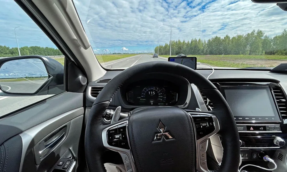Фото Mitsubishi Pajero Sport — руль. Обшивка обода и компоновка спиц крупным планом. Обогрев обода — опция, которую оценят зимой Mitsubishi Pajero Sport — руль
