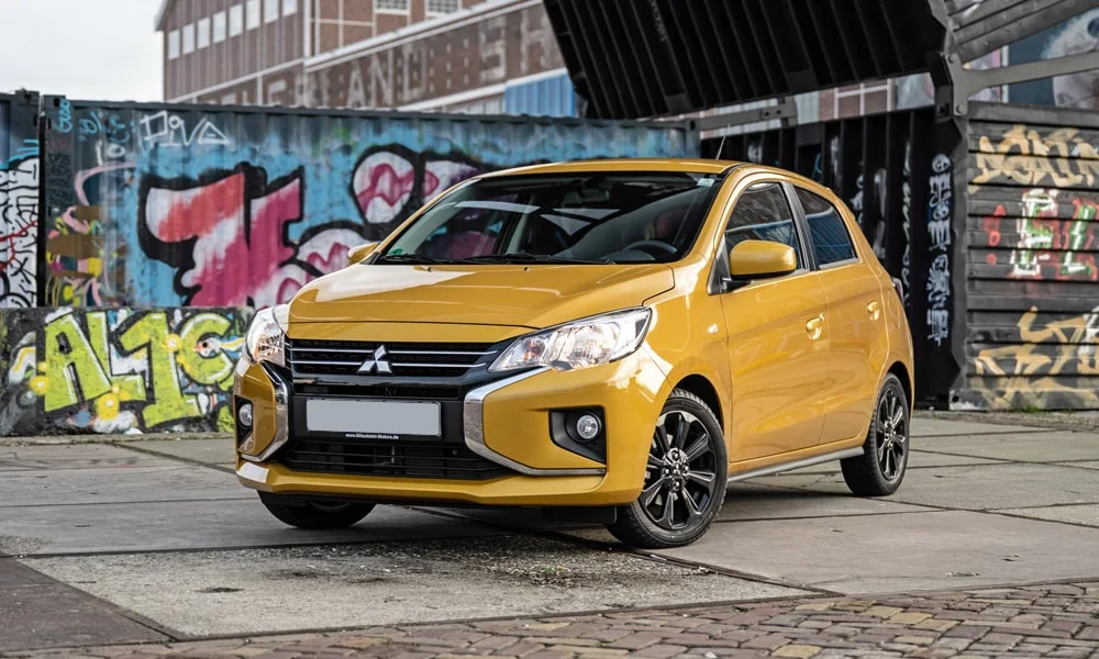Фото Mitsubishi Space Star — вид спереди, фото 4. Передок в жёлтом исполнении — крупная светотехника и выразительный бампер. Дневные ходовые огни включаются автоматически с запуском Mitsubishi Space Star — вид спереди, фото 4