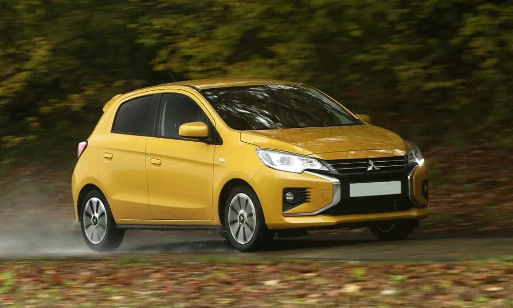 Фото Mitsubishi Space Star — вид спереди, фото 8. Жёлтый кузов, строгая симметрия оптики — базовый ракурс знакомства с дизайном. Дневные ходовые огни включаются автоматически с запуском Mitsubishi Space Star — вид спереди, фото 8