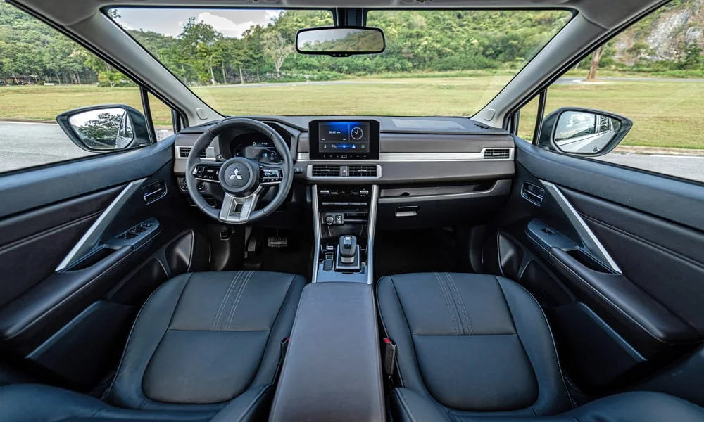 Фото Mitsubishi Xpander (2024) — интерьер. Общий план салона: архитектура панели, консоль и кресла. Уровень отделки читается по стыкам панелей и мягким поверхностям в зонах касания Mitsubishi Xpander (2024) — интерьер