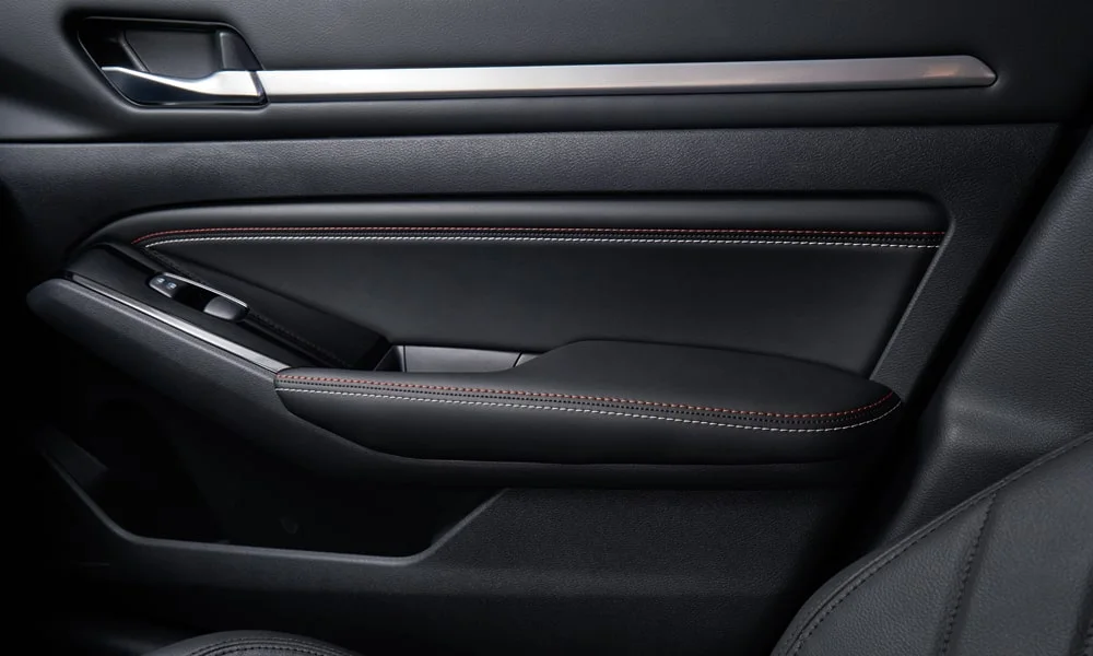 Фото Nissan Altima (2024) — дверная карта. Внутренняя панель двери: сочетание материалов и компоновка управления в тёмной гамме Nissan Altima (2024) — дверная карта