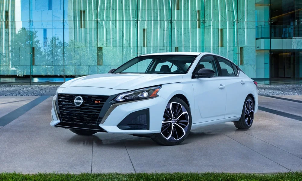 Фото Nissan Altima (2024) — вид спереди, фото 8. Белый кузов, строгая симметрия оптики — базовый ракурс знакомства с дизайном Nissan Altima (2024) — вид спереди, фото 8