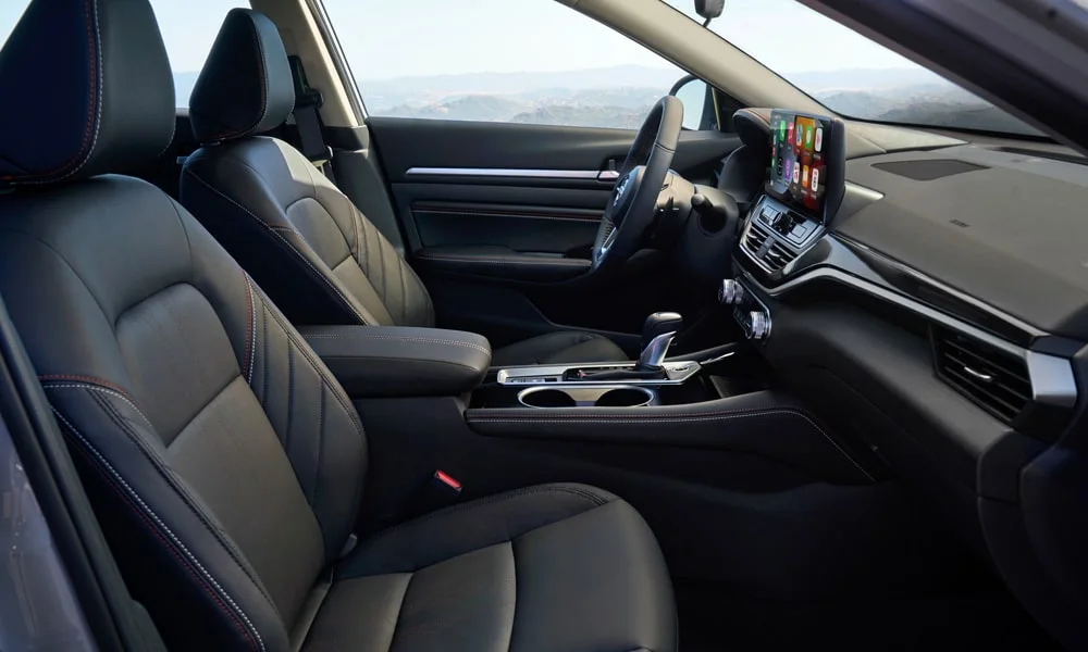 Фото Nissan Altima (2024) — интерьер, фото 2. Общий план салона: архитектура панели, консоль и кресла. Светлая гамма зрительно расширяет салон, тёмная — практичнее в уходе Nissan Altima (2024) — интерьер, фото 2