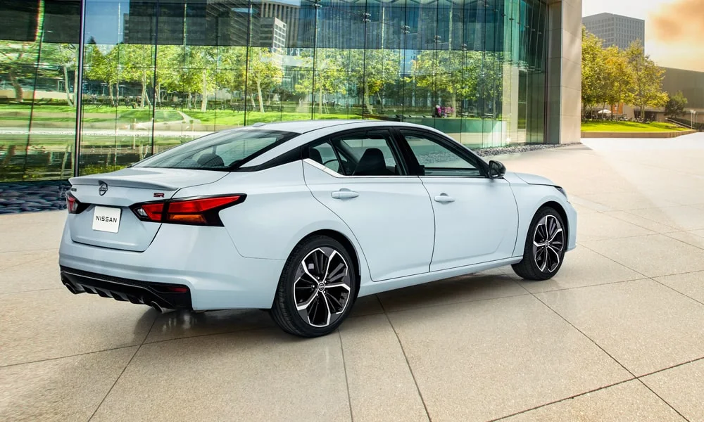 Фото Nissan Altima (2024) — вид сзади, фото 8. Корма в белом цвете: графика фонарей и пластика пятой двери. Насадки выхлопа или их имитация внизу бампера различают версии Nissan Altima (2024) — вид сзади, фото 8