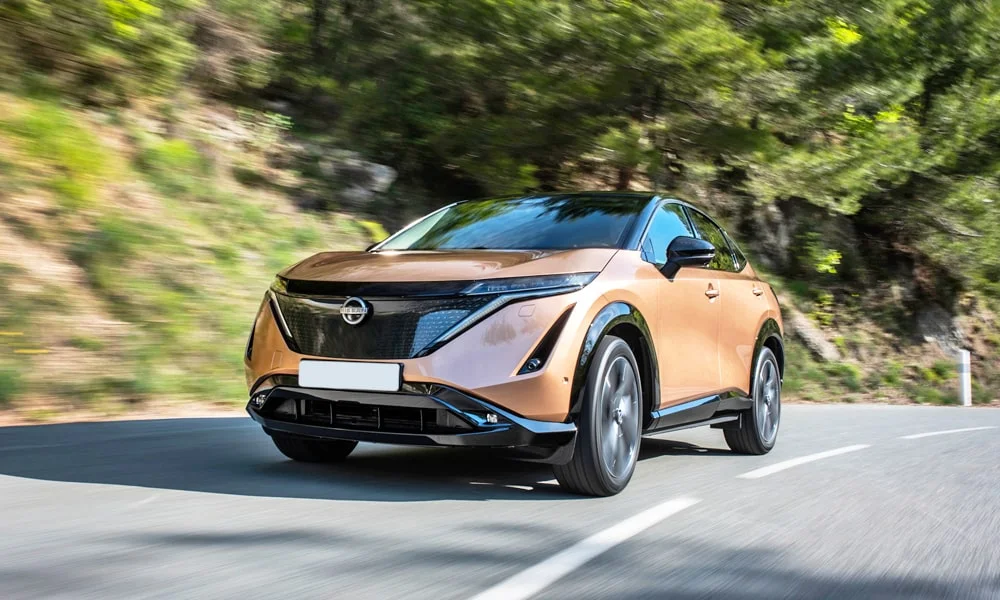 Фото Nissan Ariya (2024) — вид спереди, фото 7. Передок в коричневом исполнении — крупная светотехника и выразительный бампер. Дневные ходовые огни включаются автоматически с запуском Nissan Ariya (2024) — вид спереди, фото 7