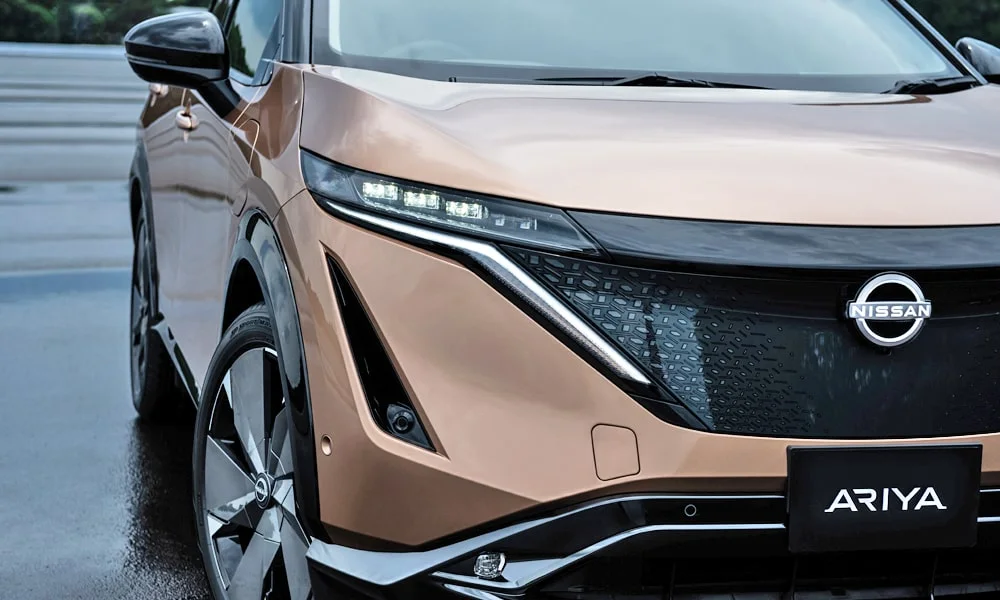 Фото Nissan Ariya (2024) — вид спереди, фото 11. Анфас: пропорции капота, посадка кузова и графика ходовых огней Nissan Ariya (2024) — вид спереди, фото 11