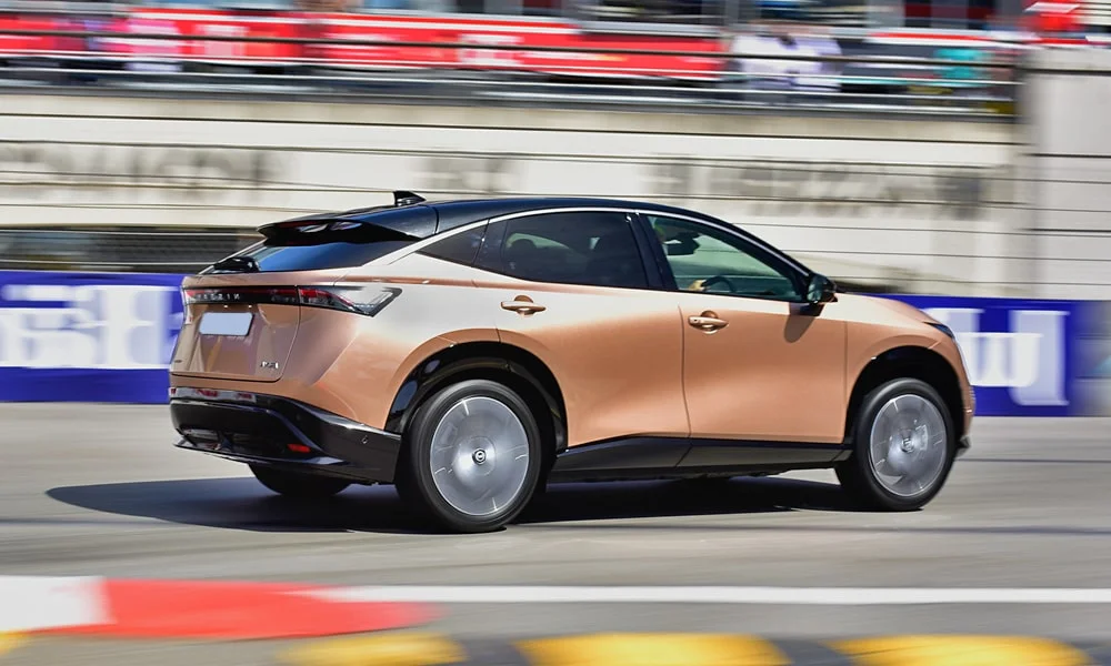 Фото Nissan Ariya (2024) — вид сзади, фото 4. Графика фонарей, бампер и оформление пятой двери. Светодиодная полоса или раздельные секции — задняя оптика стала главным украшением кормы Nissan Ariya (2024) — вид сзади, фото 4