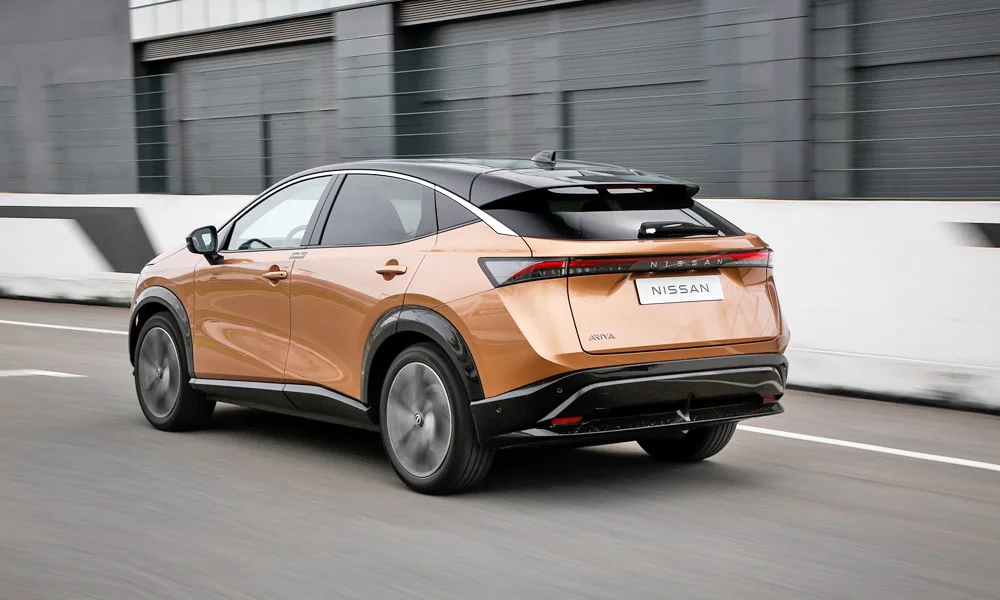 Фото Nissan Ariya (2024) — вид сзади, фото 6. Графика фонарей, бампер и оформление пятой двери. Насадки выхлопа или их имитация внизу бампера различают версии Nissan Ariya (2024) — вид сзади, фото 6
