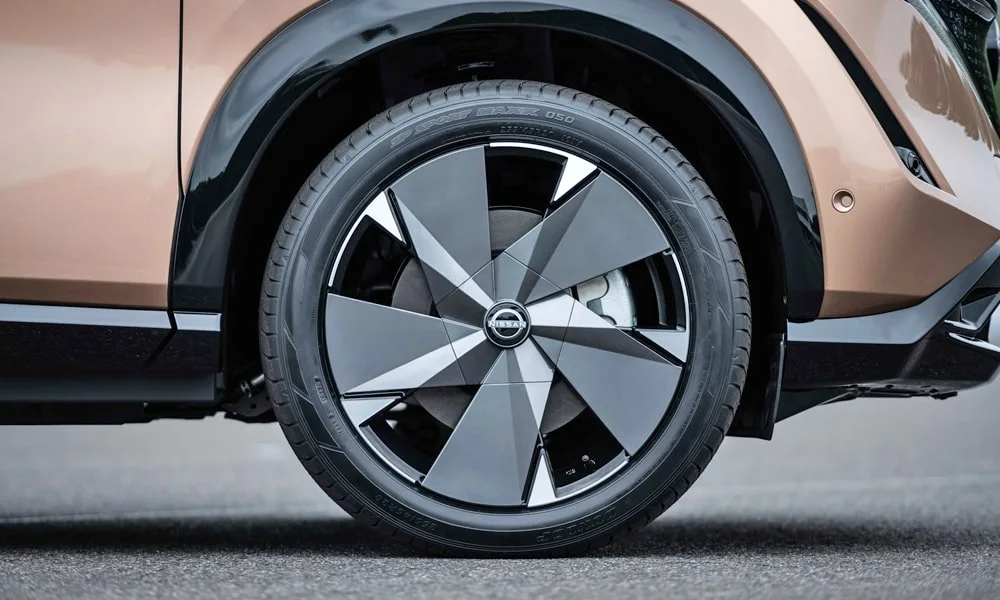 Фото Nissan Ariya (2024) — колесо и диск. Аэродинамический дизайн колеса снижает расход на трассе. Рекомендованные размеры шин и давление — на табличке в проёме водительской двери Nissan Ariya (2024) — колесо и диск