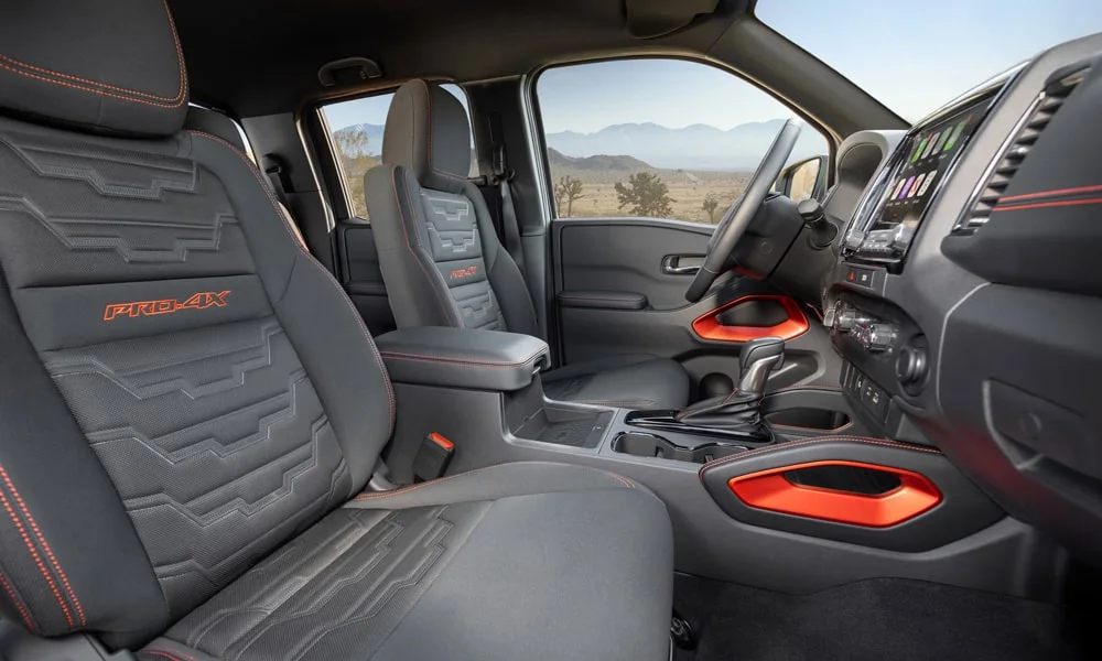 Фото Nissan Frontier (2024) — передние сиденья. Передние кресла в практичной ткани. Регулировки с памятью возвращают кресло под водителя одним нажатием — у версий с электроприводом Nissan Frontier (2024) — передние сиденья