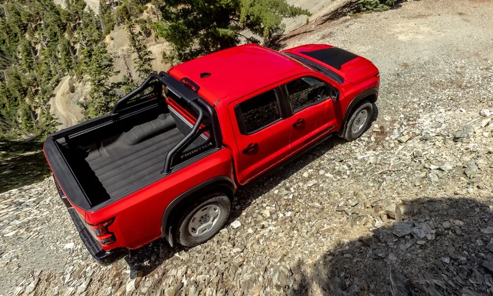 Фото Nissan Frontier (2024) — вид сзади, фото 10. Красный кузов сзади — фонари и бампер определяют ночной образ модели. Насадки выхлопа или их имитация внизу бампера различают версии Nissan Frontier (2024) — вид сзади, фото 10