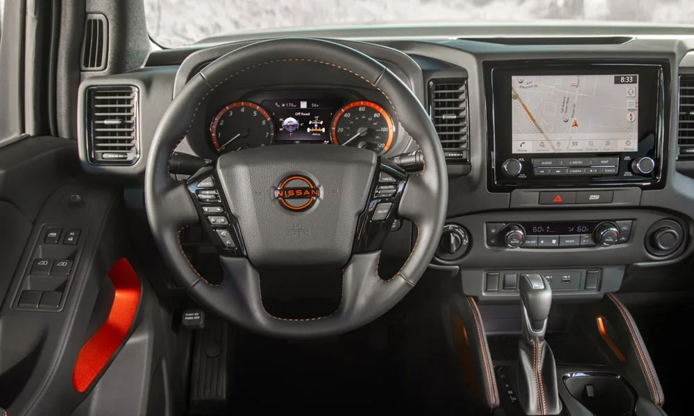 Фото Nissan Frontier (2024) — руль. Обшивка обода и компоновка спиц крупным планом. Правильная посадка: руки на «9 и 3», приборы читаются поверх обода Nissan Frontier (2024) — руль