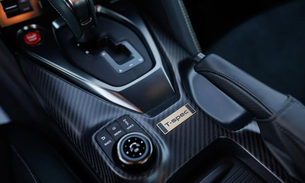 Фото Nissan GT-R — селектор коробки передач. Селектор трансмиссии на центральной консоли. Режимы движения и электронный ручник собраны рядом с селектором Nissan GT-R — селектор коробки передач