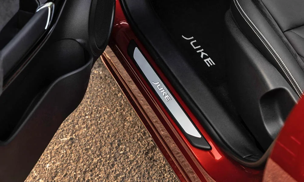 Фото Nissan Juke (2024) — дверная карта. Подлокотник, динамик и блок стеклоподъёмников. Решётка динамика в двери — часть штатной акустики Nissan Juke (2024) — дверная карта