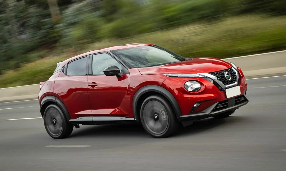 Фото Nissan Juke (2024) — вид спереди, фото 5. Кузов в красном цвете: рисунок оптики и решётки задаёт узнаваемое «лицо» модели. Дневные ходовые огни включаются автоматически с запуском Nissan Juke (2024) — вид спереди, фото 5
