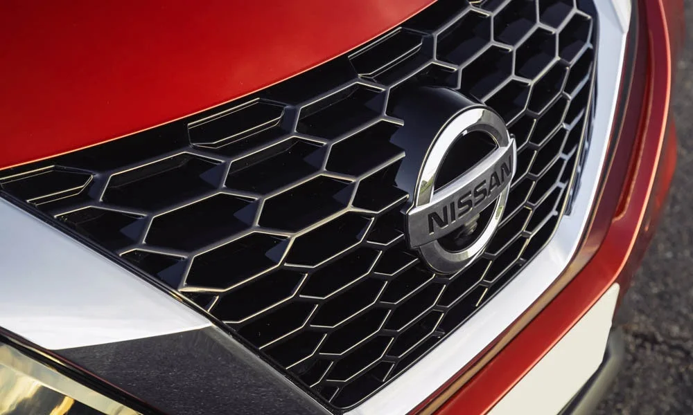 Фото Nissan Juke (2024) — решётка радиатора. Рисунок решётки: сетка, ламели или глухая панель у электроверсий. За решёткой у многих комплектаций стоит радар адаптивного круиз-контроля Nissan Juke (2024) — решётка радиатора