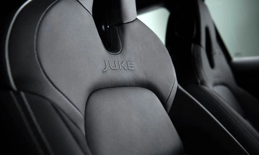Фото Nissan Juke (2024) — интерьер, фото 2. Общий план салона: архитектура панели, консоль и кресла. Светлая гамма зрительно расширяет салон, тёмная — практичнее в уходе Nissan Juke (2024) — интерьер, фото 2