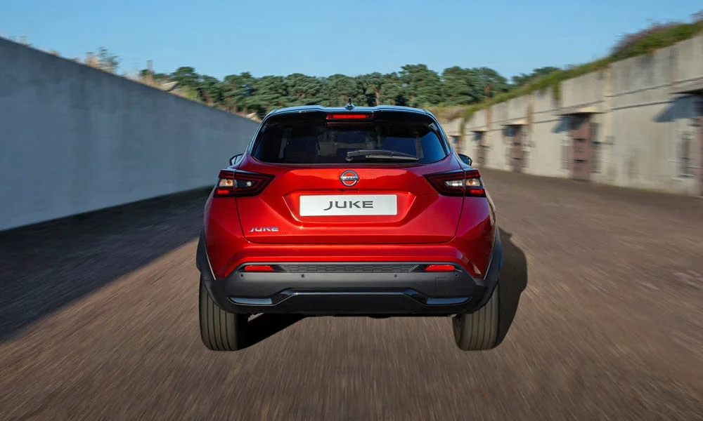 Фото Nissan Juke (2024) — вид сзади, фото 8. Корма в красном цвете: графика фонарей и пластика пятой двери. Светодиодная полоса или раздельные секции — задняя оптика стала главным украшением кормы Nissan Juke (2024) — вид сзади, фото 8