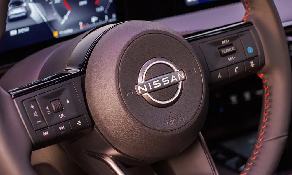 Фото Nissan Kicks (2024) — руль. Обшивка обода и компоновка спиц крупным планом. Клавиши на спицах управляют медиа, круизом и ассистентами — руки остаются на руле Nissan Kicks (2024) — руль