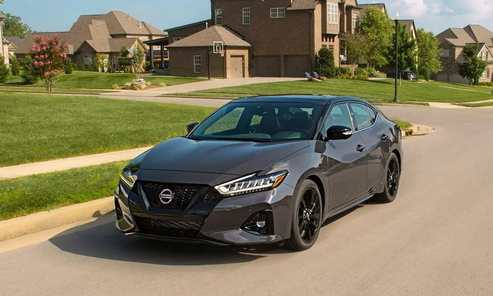 Фото Nissan Maxima — вид спереди, фото 12. Кузов в сером цвете: рисунок оптики и решётки задаёт узнаваемое «лицо» модели. Рисунок ходовых огней — подпись модели, по нему её узнают в потоке Nissan Maxima — вид спереди, фото 12