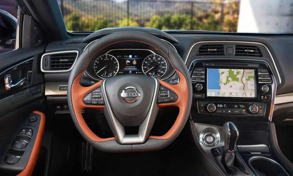 Фото Nissan Maxima — руль. Обшивка обода и компоновка спиц крупным планом. Обогрев обода — опция, которую оценят зимой Nissan Maxima — руль