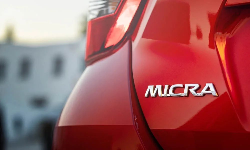 Фото Nissan Micra — эмблема. Логотип марки крупным планом Nissan Micra — эмблема