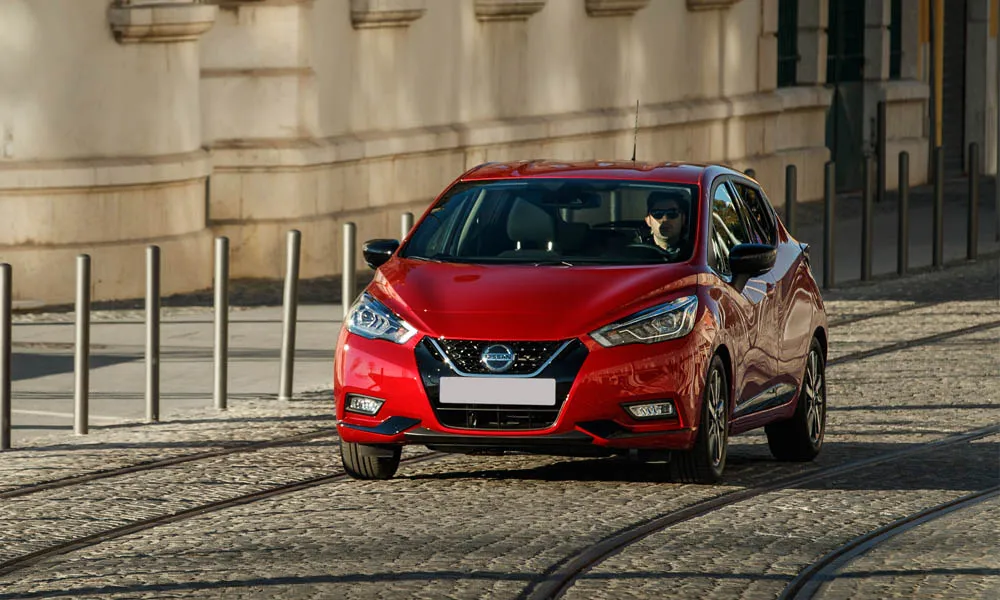 Фото Nissan Micra — вид спереди, фото 16. Передок в красном исполнении — крупная светотехника и выразительный бампер. Рисунок ходовых огней — подпись модели, по нему её узнают в потоке Nissan Micra — вид спереди, фото 16