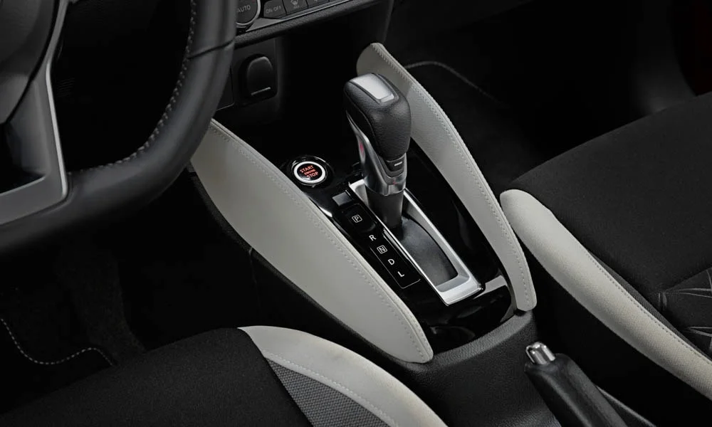 Фото Nissan Micra — селектор коробки передач. Селектор трансмиссии на центральной консоли. Режимы движения и электронный ручник собраны рядом с селектором Nissan Micra — селектор коробки передач