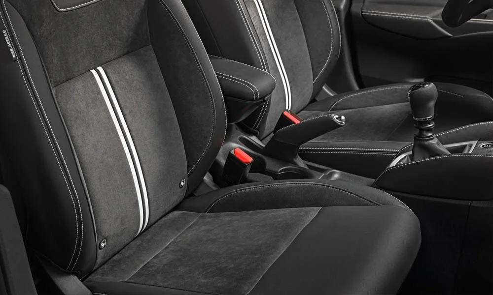 Фото Nissan Micra — интерьер. Общий план салона: архитектура панели, консоль и кресла. Светлая гамма зрительно расширяет салон, тёмная — практичнее в уходе Nissan Micra — интерьер