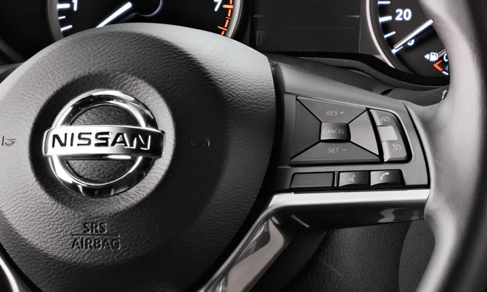 Фото Nissan Micra — руль, фото 2. Обшивка обода и компоновка спиц крупным планом. Клавиши на спицах управляют медиа, круизом и ассистентами — руки остаются на руле Nissan Micra — руль, фото 2