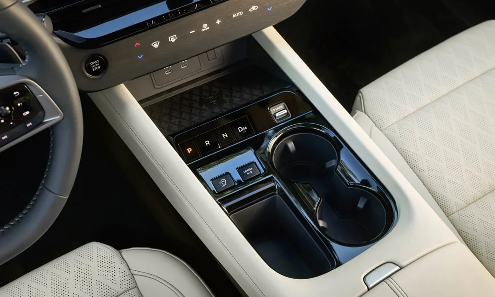 Фото Nissan Murano — центральная консоль. Подстаканники и ниши для мелочей между креслами. Продуманное хранение: подстаканники, ниша для смартфона и глубокий бокс Nissan Murano — центральная консоль