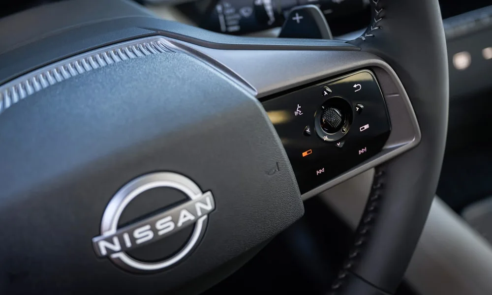 Фото Nissan Murano — руль. Обшивка обода и компоновка спиц крупным планом. Клавиши на спицах управляют медиа, круизом и ассистентами — руки остаются на руле Nissan Murano — руль