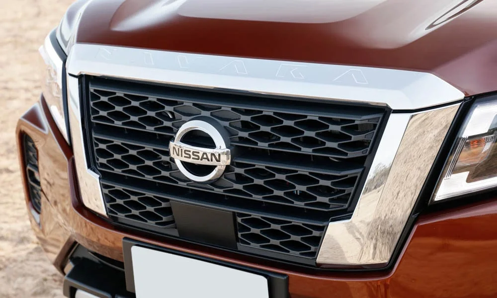 Фото Nissan Navara — решётка радиатора. Фирменный рисунок облицовки — визитная карточка марки Nissan Navara — решётка радиатора