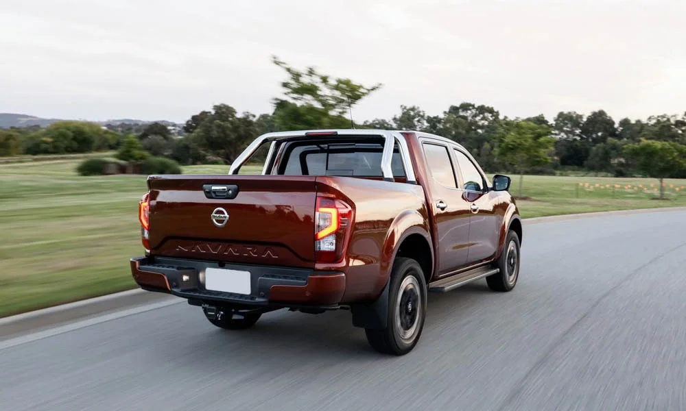 Фото Nissan Navara — вид сзади, фото 2. Корма в коричневом цвете: графика фонарей и пластика пятой двери Nissan Navara — вид сзади, фото 2