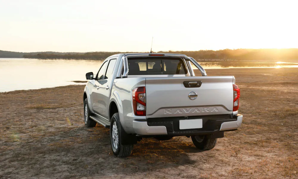 Фото Nissan Navara — вид сзади, фото 5. Корма в серебристом цвете: графика фонарей и пластика пятой двери. Насадки выхлопа или их имитация внизу бампера различают версии Nissan Navara — вид сзади, фото 5