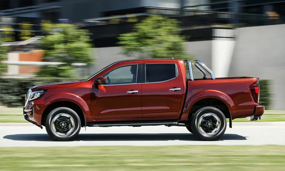 Фото Nissan Navara — вид сбоку. Сбоку читаются линия остекления и характер выштамповок на красном кузове. Длинная база — простор второго ряда; короткие свесы упрощают парковку Nissan Navara — вид сбоку