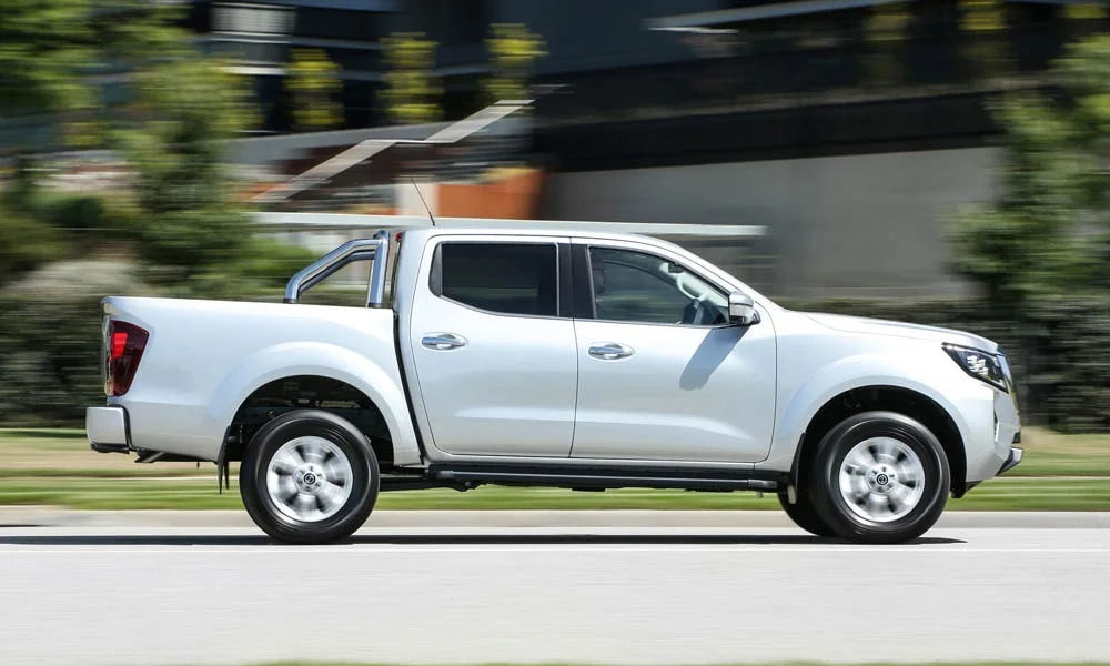 Фото Nissan Navara — вид сбоку, фото 3. Белый кузов в профиль — пропорции, высота посадки и дизайн дисков. Длинная база — простор второго ряда; короткие свесы упрощают парковку Nissan Navara — вид сбоку, фото 3