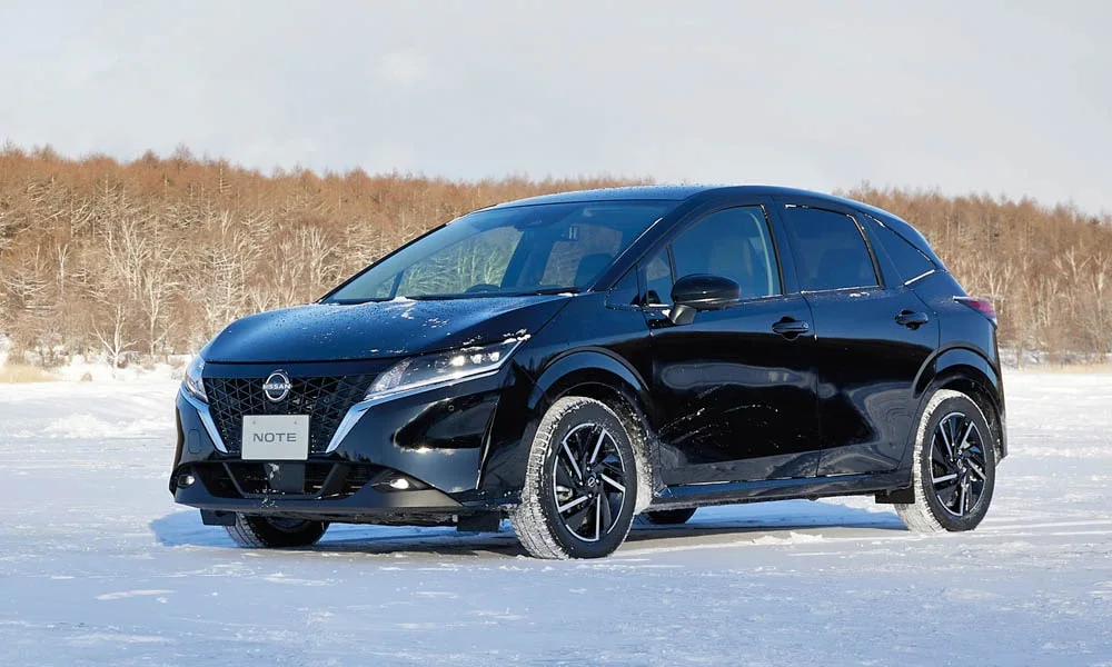 Фото Nissan Note — вид спереди, фото 6. Чёрный кузов, строгая симметрия оптики — базовый ракурс знакомства с дизайном. Дневные ходовые огни включаются автоматически с запуском Nissan Note — вид спереди, фото 6