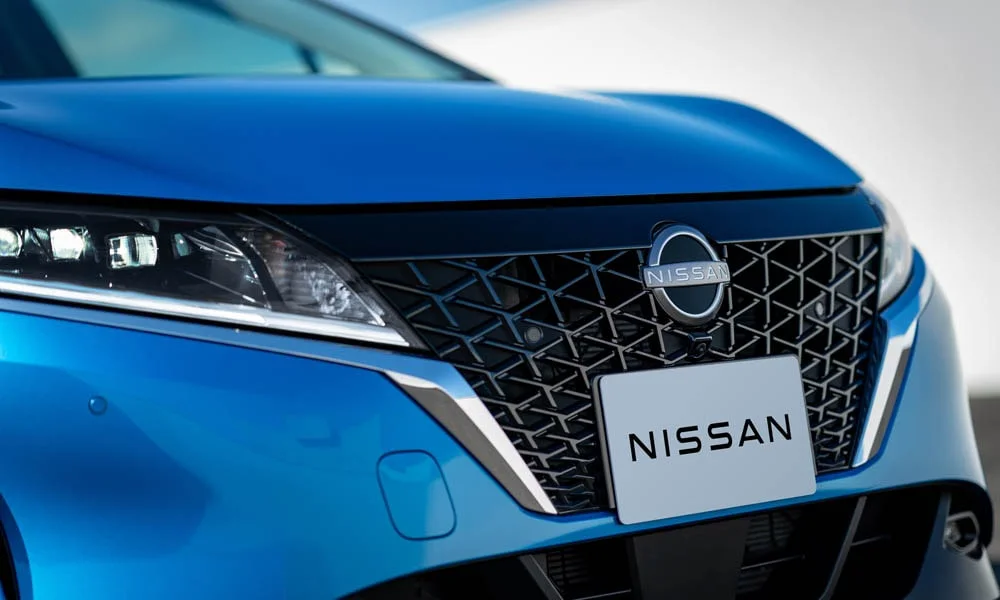 Фото Nissan Note — решётка радиатора. Рисунок решётки: сетка, ламели или глухая панель у электроверсий. За решёткой у многих комплектаций стоит радар адаптивного круиз-контроля Nissan Note — решётка радиатора
