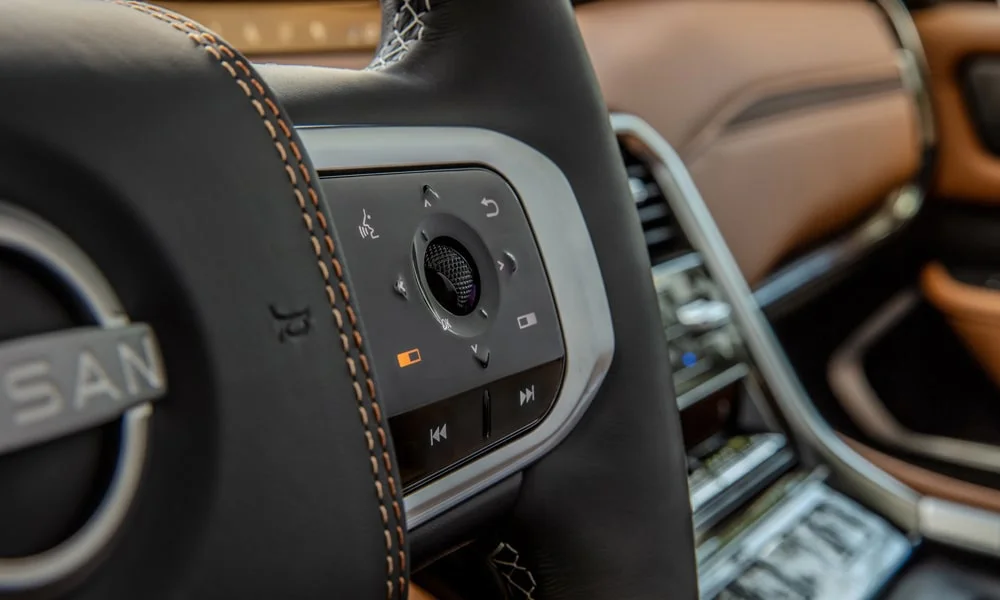 Фото Nissan Patrol (2024) — руль. Обшивка обода и компоновка спиц крупным планом. Правильная посадка: руки на «9 и 3», приборы читаются поверх обода Nissan Patrol (2024) — руль