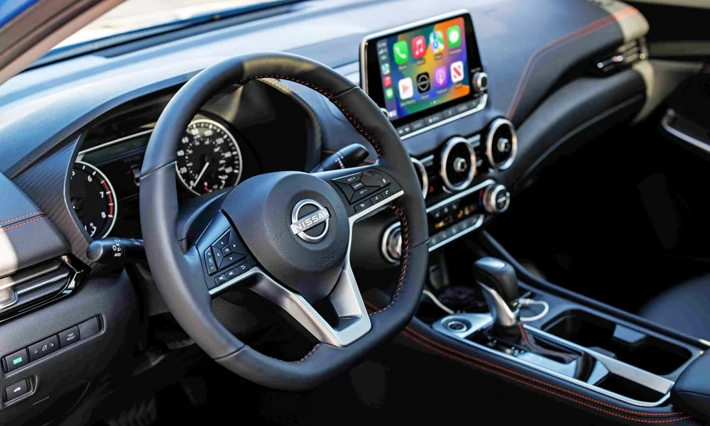 Фото Nissan Sentra — передняя панель. Архитектура передней панели: ярусы, вставки и консоль в тёмно-синей гамме Nissan Sentra — передняя панель
