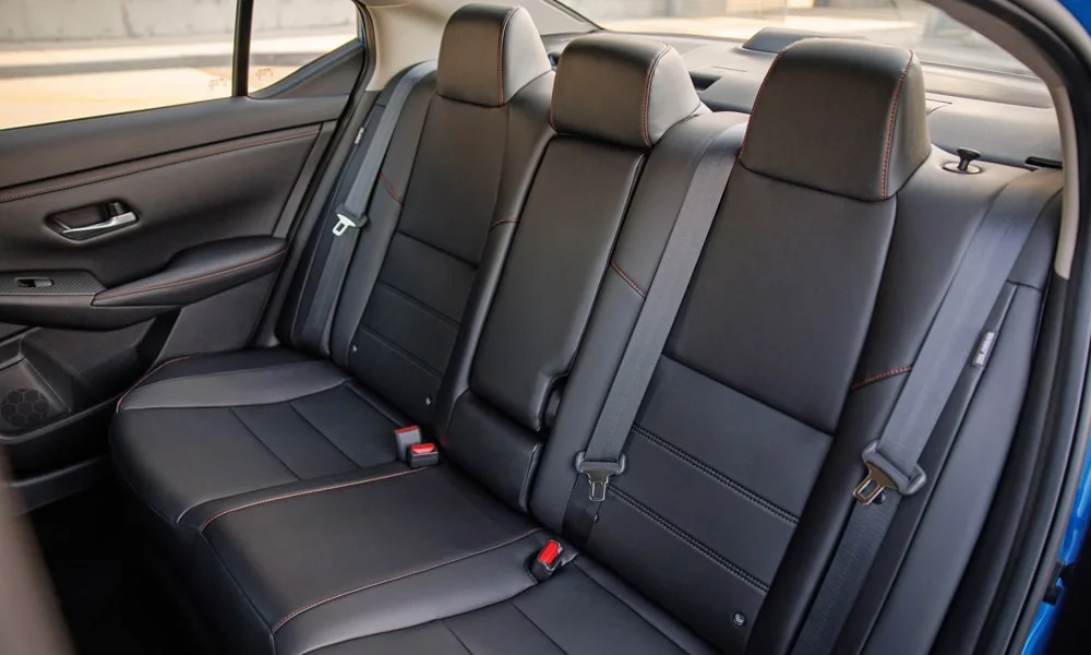 Фото Nissan Sentra — задние сиденья. Посадка второго ряда: подголовники и подлокотник. Спинки складываются под длинные грузы у большинства версий Nissan Sentra — задние сиденья
